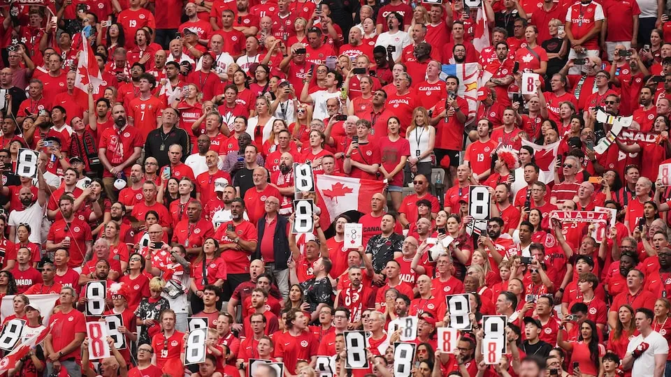 Fans hold up #8 for Koné in the eighth minute to honour the Canadian midfielder