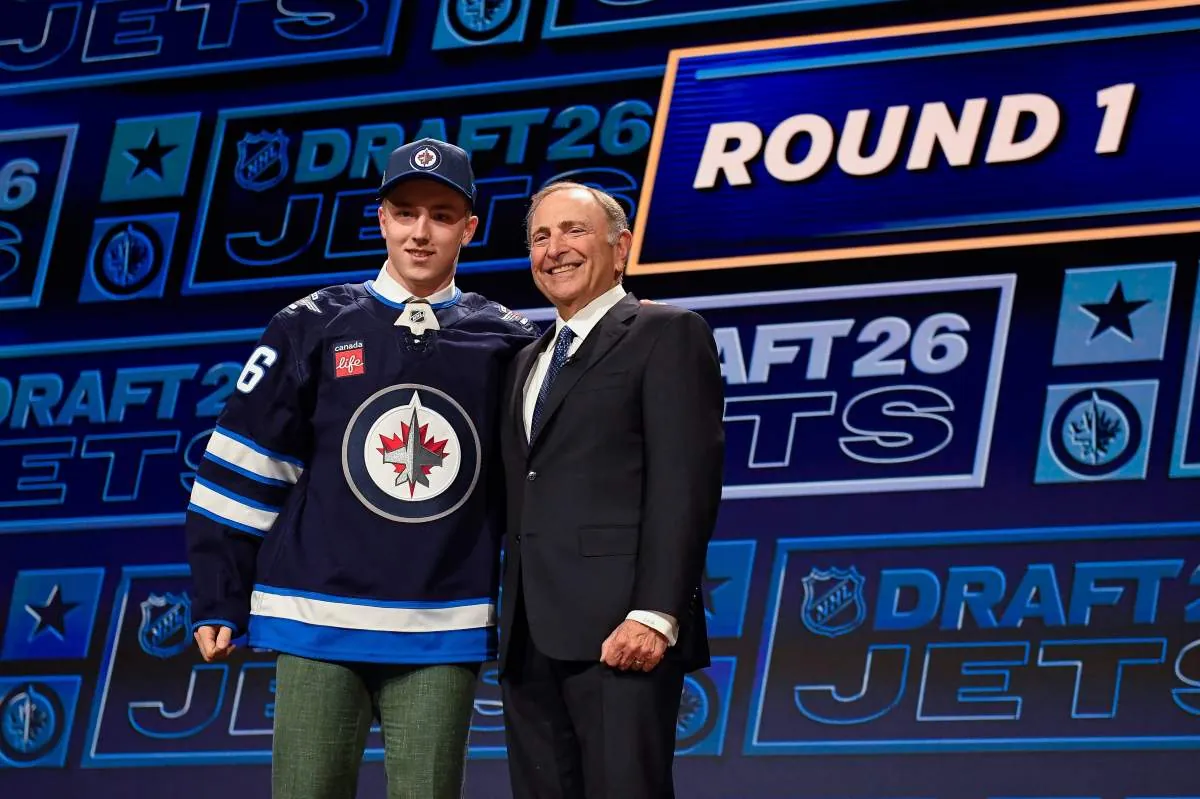 Viggo Bjorck, left, stands with NHL Commissioner Gary Bettman, right, after being drafted by the Winnipeg Jets during the NHL hockey draft Friday, June 26, 2026, in Buffalo, N.Y. (AP Photo/Adrian Kraus).