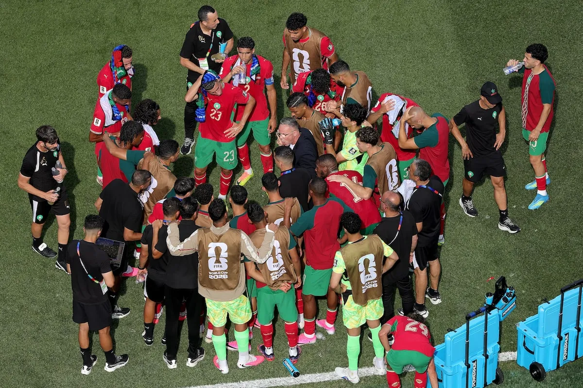 Mohamed Ouahbi, Head Coach of Morocco, speaks to players in the huddle at a hydration break during the World Cup match.Alex Slitz/Getty Images